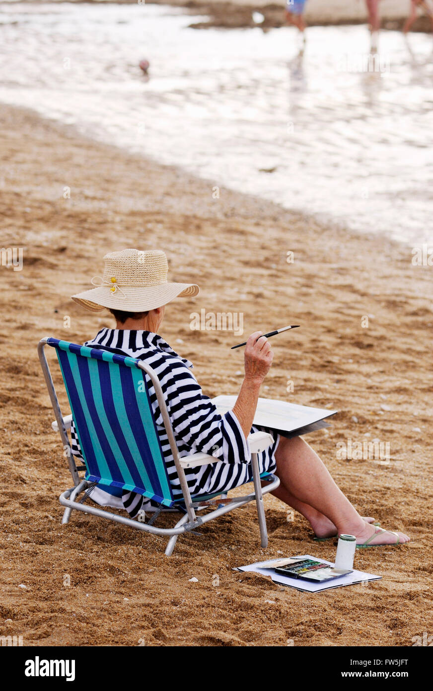 Lady-Aquarell-Maler an einem Strand in der Normandie. Stockfoto