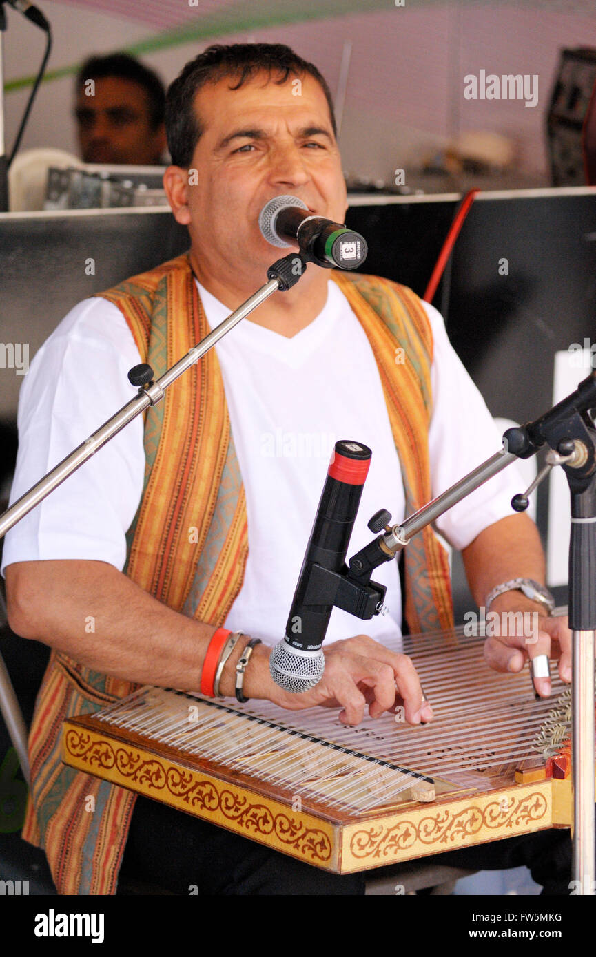 Türkische Musiker auf eine türkische Kanun (Qanun - Zither). Es hat 26 Trio Saiten in allen 78 Saiten; auf den beiden Knien mit zwei Metall Plektren an den Fingern gespielt. Ihr Klang ist wie die australischen Zither und ungarischen Cymbalum. Die Brücke besteht aus einem Kelebek Baum oder ein Horn-Strahl-Baum. Saiten werden mittels Zapfen nach aus der Unterseite des Instrumentes wo sie gefesselt und ging über die Brücke angezogen. Etwa 200 Metall Heringe sind auf dem pegging Tisch dienen als Bünde ausgestattet. Dicke der Saiten reicht von 0,60 mm. bis 1,20 mm. für niedrige Stellplätze. Ca. 441 kg. Forc Stockfoto