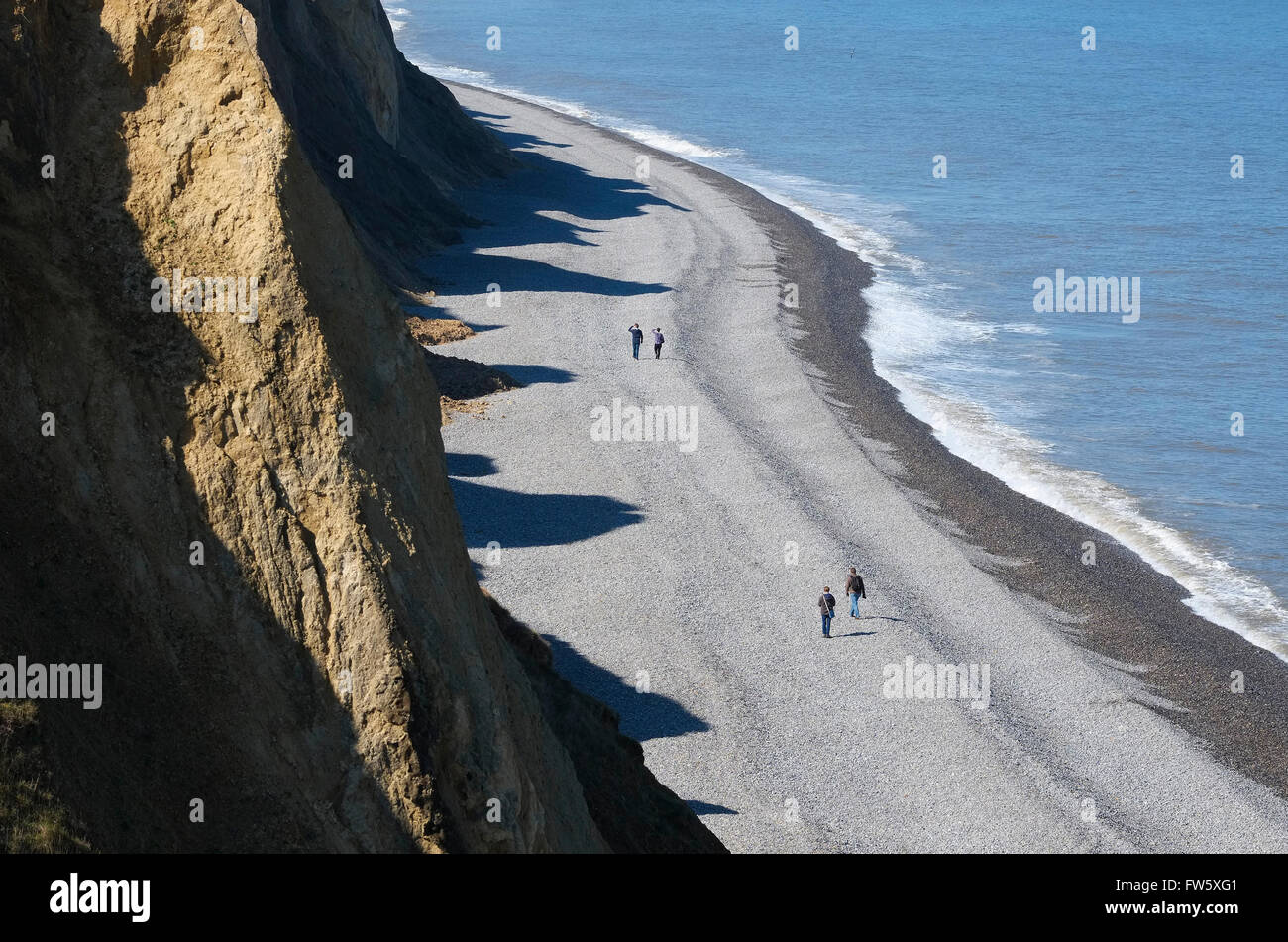 Menschen zu Fuß auf Kiesstrand in sheringham Stockfoto