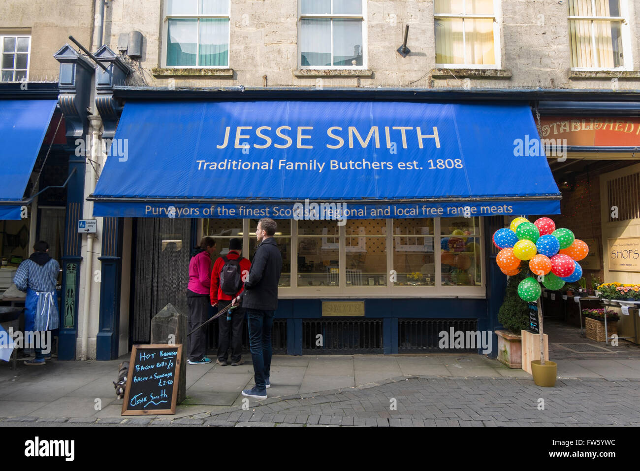 Burger und Würstchen gekocht wird außen Jesse Smith Fleischer in Black Jack Street, Cirencester, Gloucestershire, Großbritannien Stockfoto