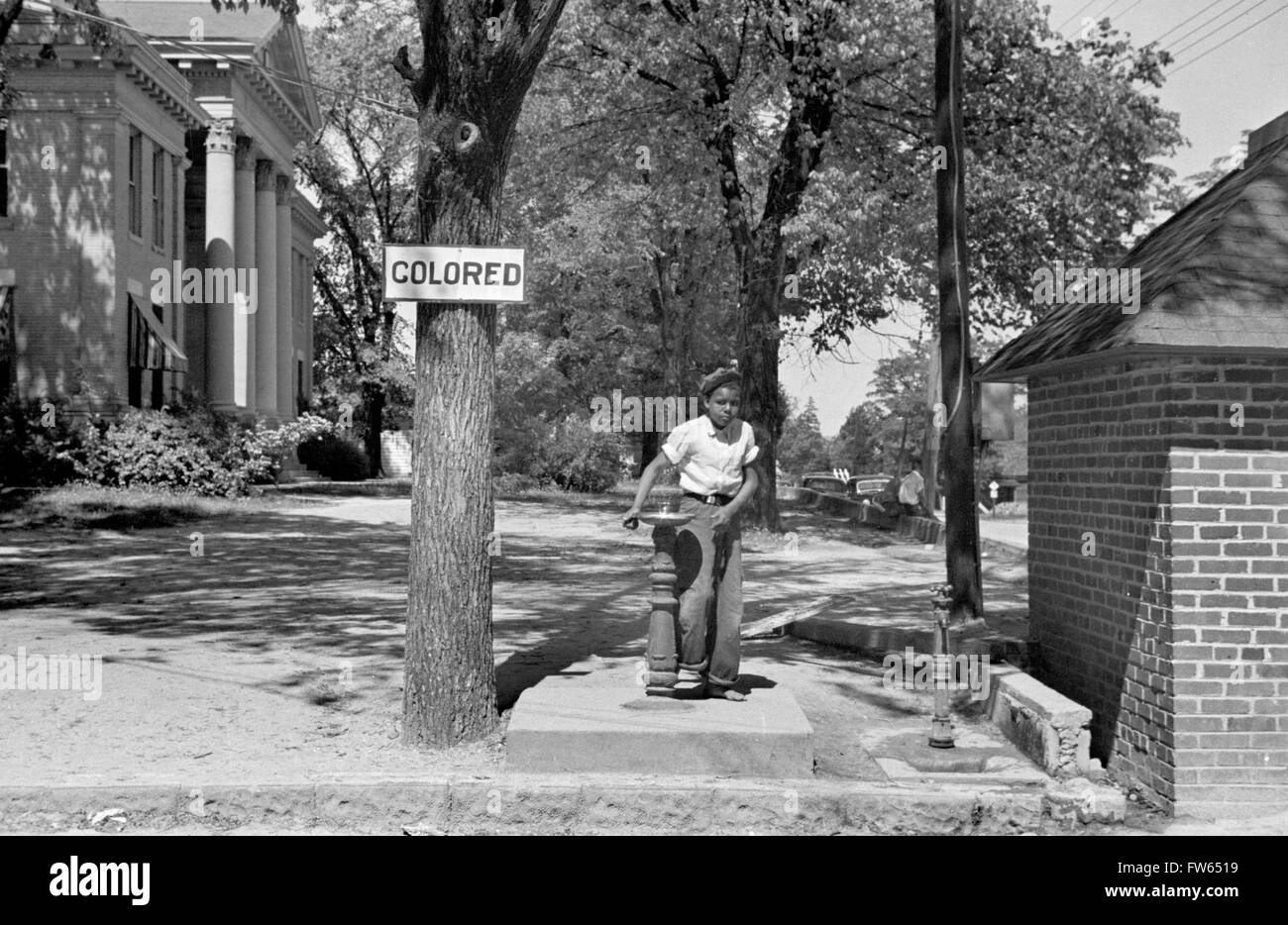 Segregation, USA. Jungen schwarzen Jungen trinken an einem Springbrunnen mit einer 'bunten' Zeichen über es, Halifax, North Carolina, Vereinigte Staaten von Amerika. Foto von John Vachon, 1938 Stockfoto