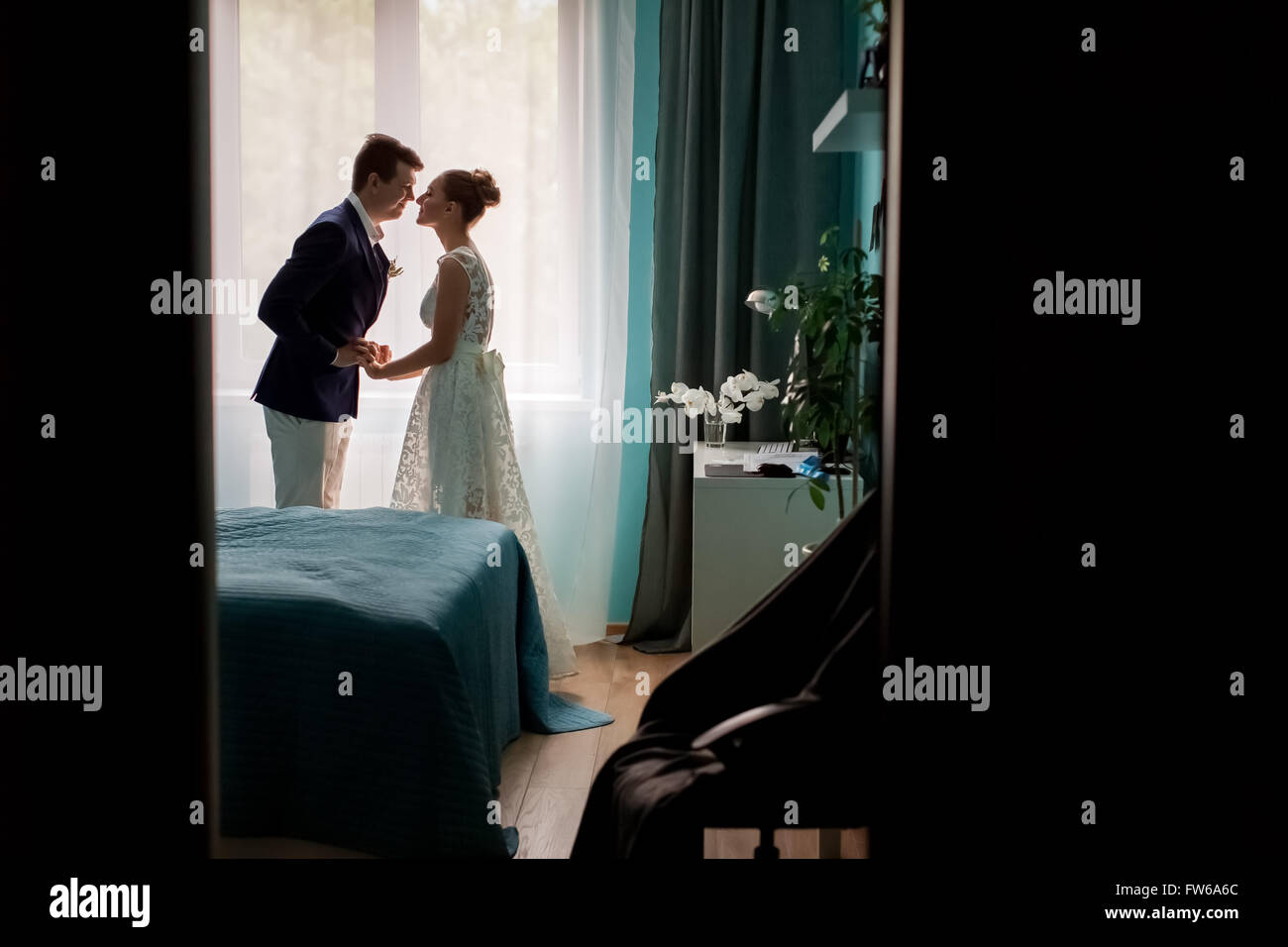 Foto voller dunkle Silhouette Brautpaar Braut und Bräutigam küssen im Fenster innen Schlafzimmer im indoor Hintergrund, Stockfoto