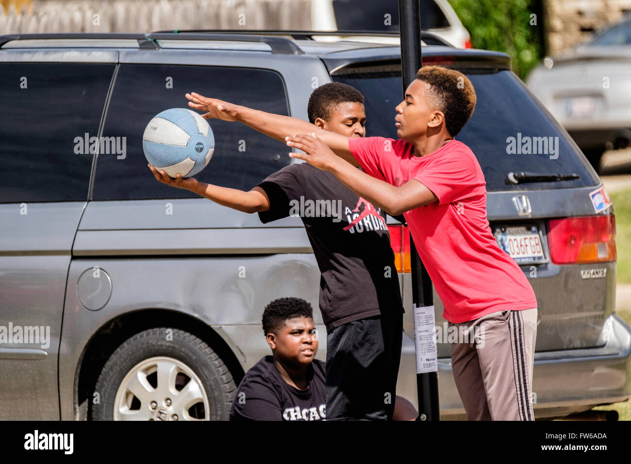 Teen und pre-teen-Boys sammeln und spielen Basketball auf der Straße in Oklahoma City, Oklahoma, USA. Stockfoto
