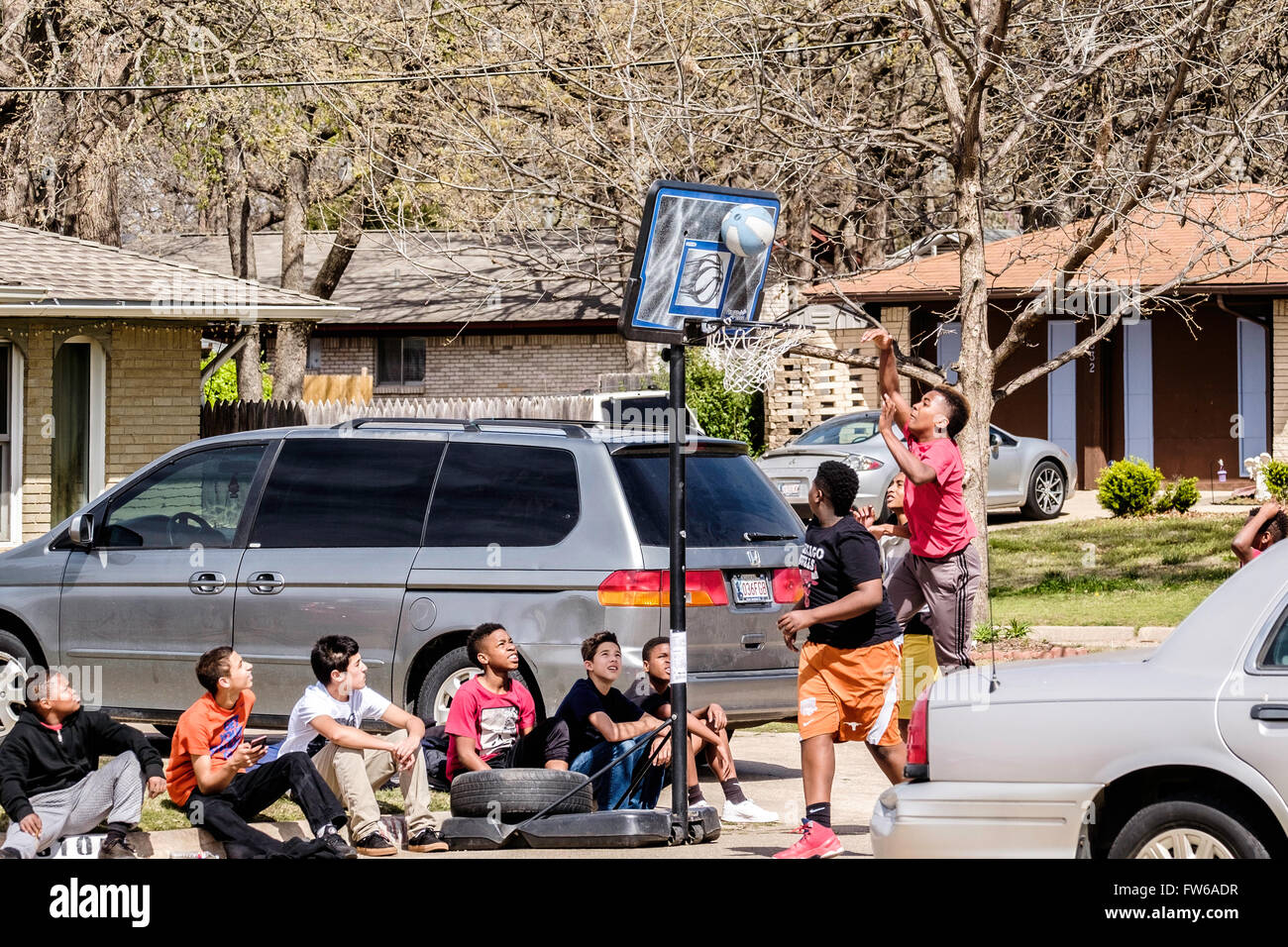 Teen und pre-teen-Boys sammeln und spielen Basketball auf der Straße in Oklahoma City, Oklahoma, USA. Stockfoto