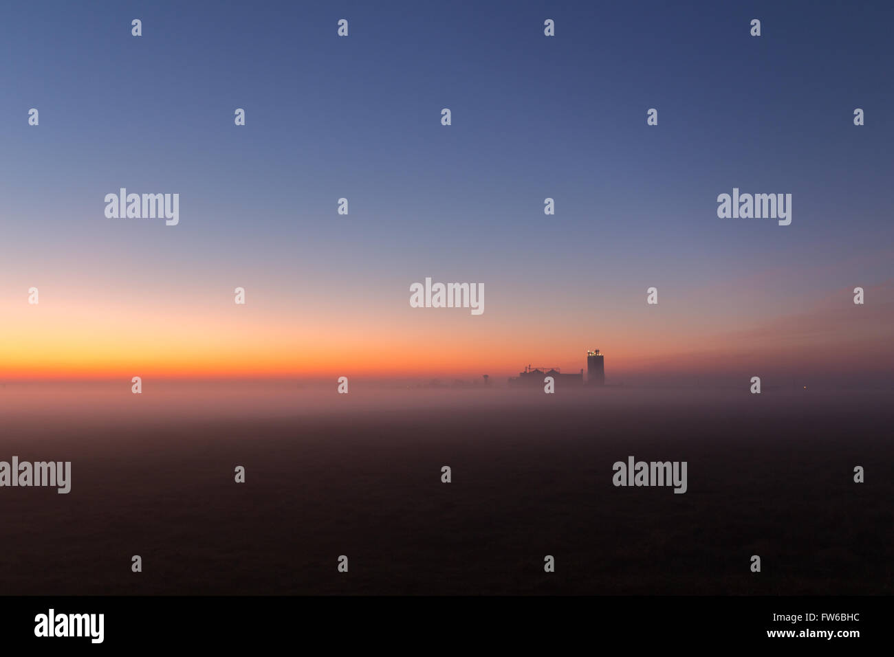 Neblig Industrielandschaft, Silhouette der alten Fabrik gegen den Sonnenuntergang Himmel und Nebel zur blauen Stunde in der Nacht Stockfoto