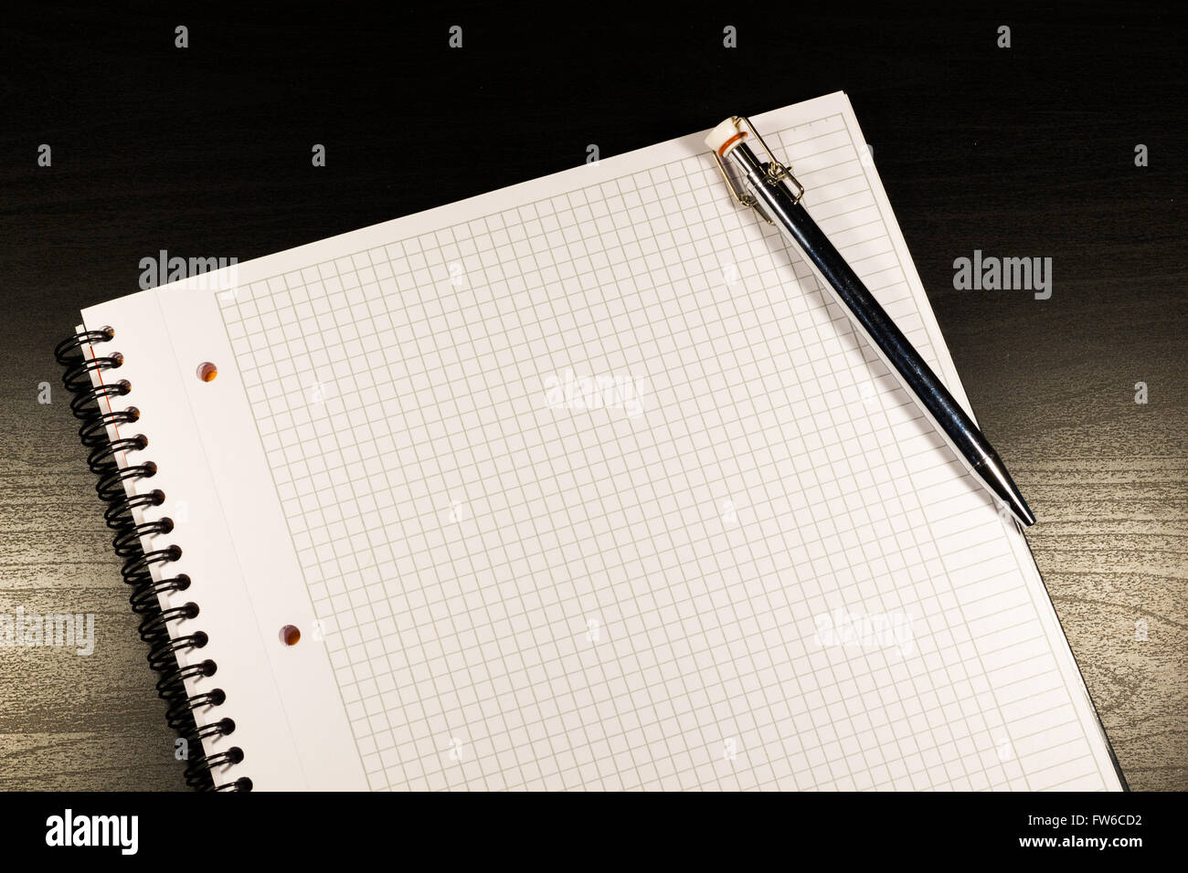 Notebook mit leeren Seiten öffnen und Bleistift auf schwarzem Hintergrund aus Holz Stockfoto