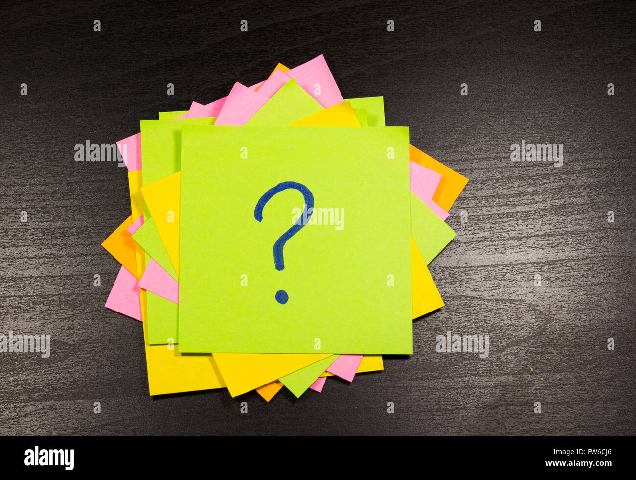 Fragezeichen auf einem Zettel auf hölzernen Hintergrund Stockfoto