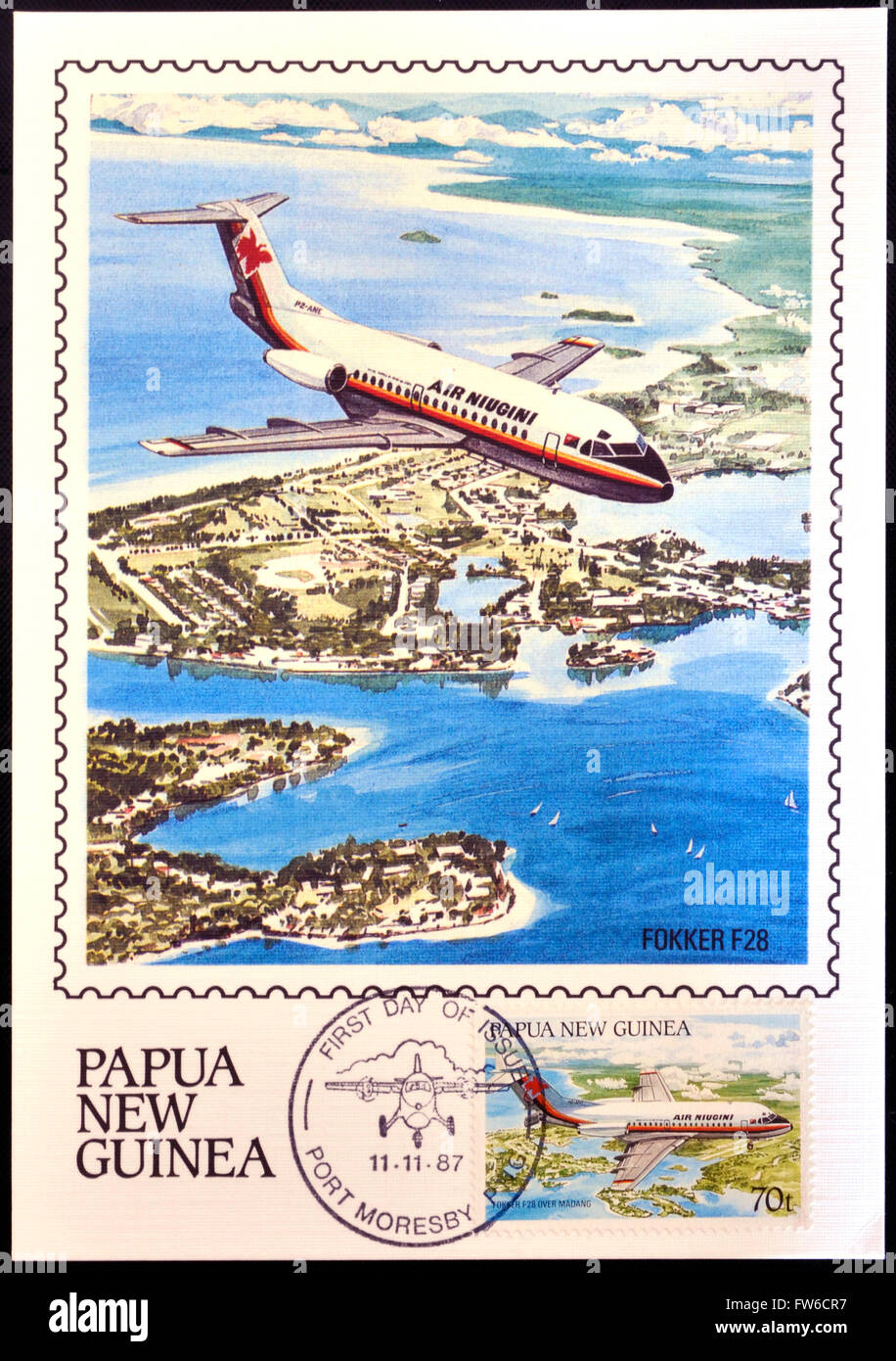 PAPUA NEUGUINEA - CIRCA 1987: Eine Briefmarke gedruckt in Papua zeigt A Fokker F28 im Flug über der Madang-Township in Madang Provi Stockfoto