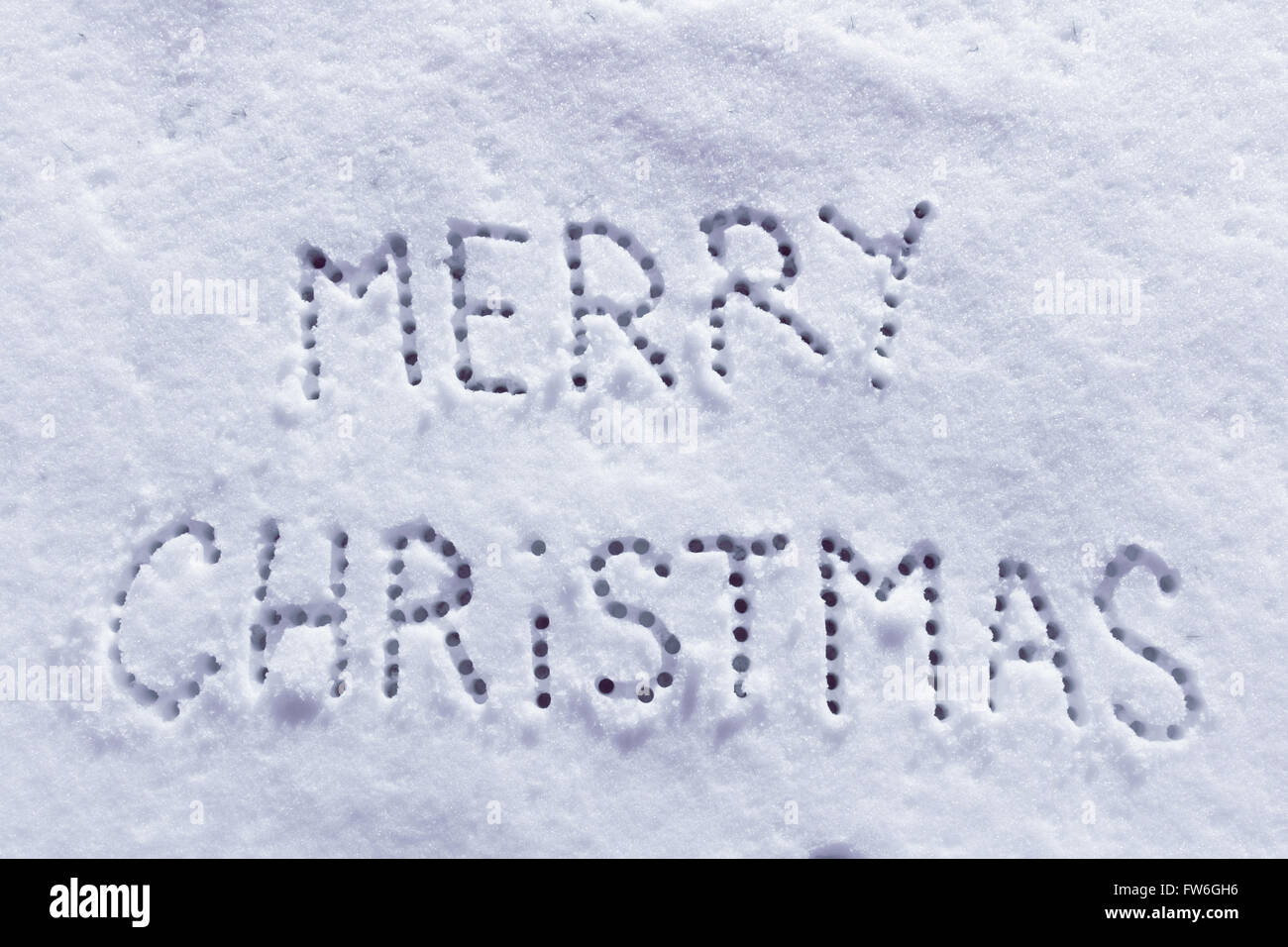 Geschriebene Worte Frohe Weihnachten auf ein Schneefeld, Neujahr-Konzept. Stockfoto