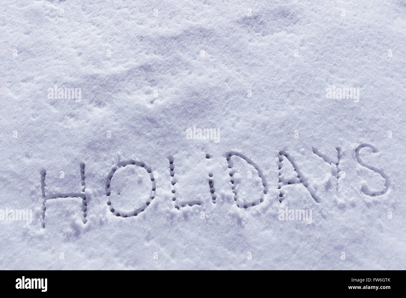 Geschriebene Wörter Urlaub auf einem Schneefeld Stockfoto