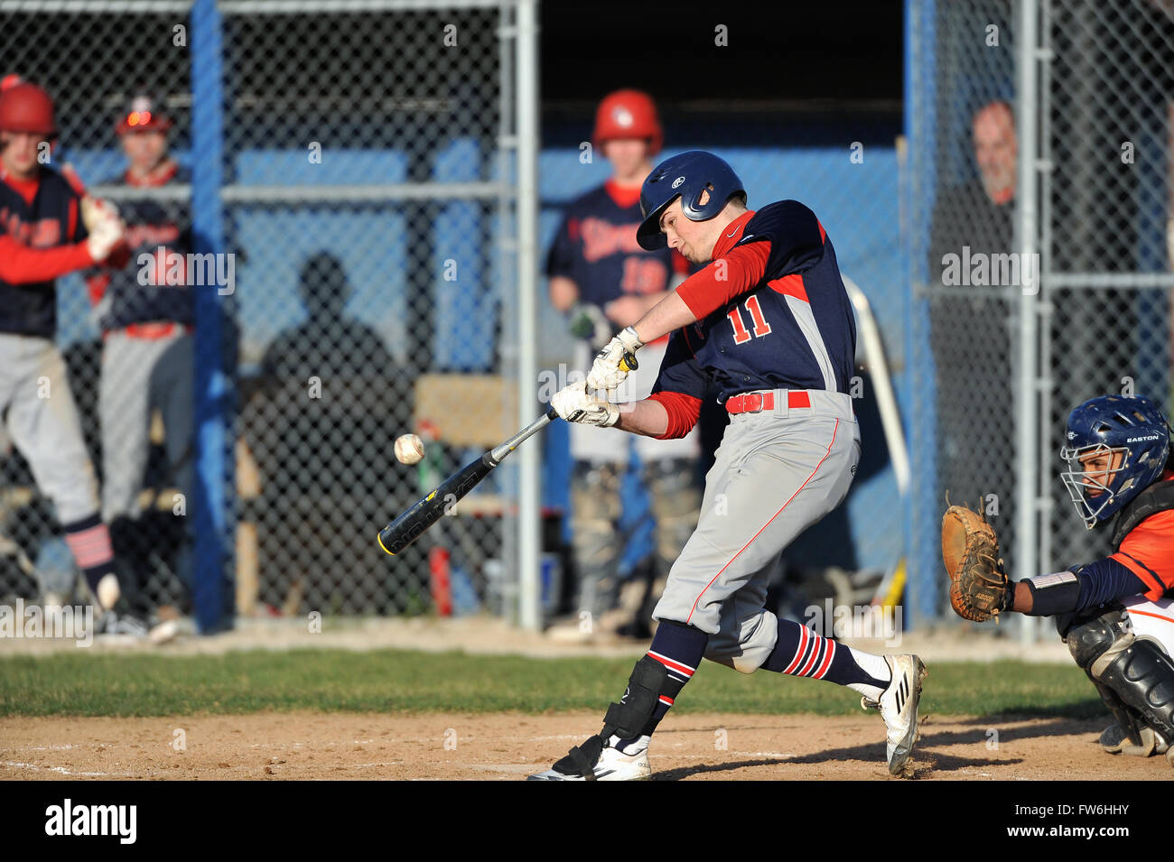 Während sein Kopf nach unten halten durch Kontakt, ein High School hitter ist mit einem scharfen Single zum outfield belohnt. USA. Stockfoto