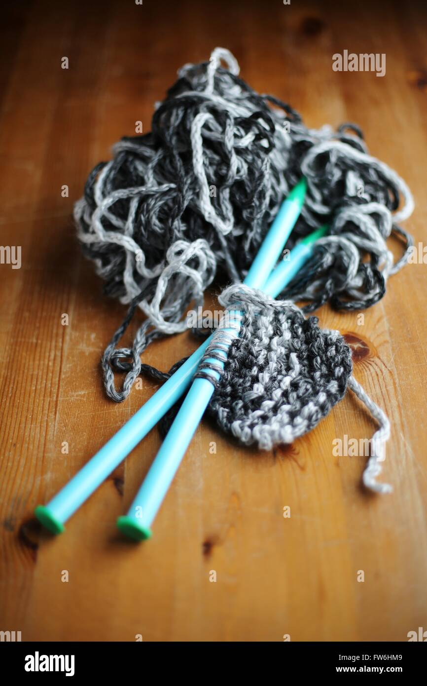 Strickende Nadeln und Garn mit einem teilweise gestrickten Schal. Stockfoto