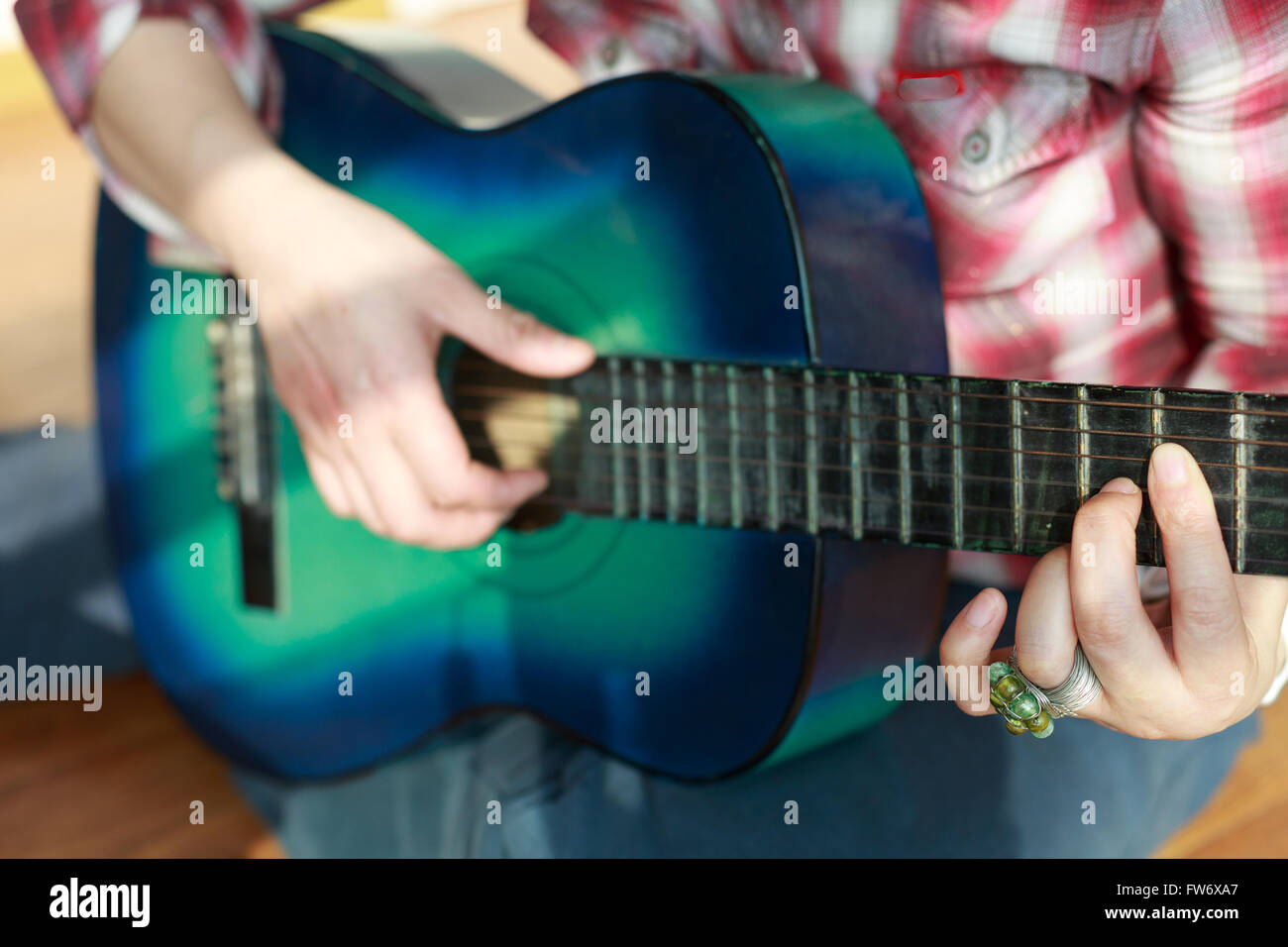 Modebewusste Frau spielt die Gitarre-Szene Stockfoto