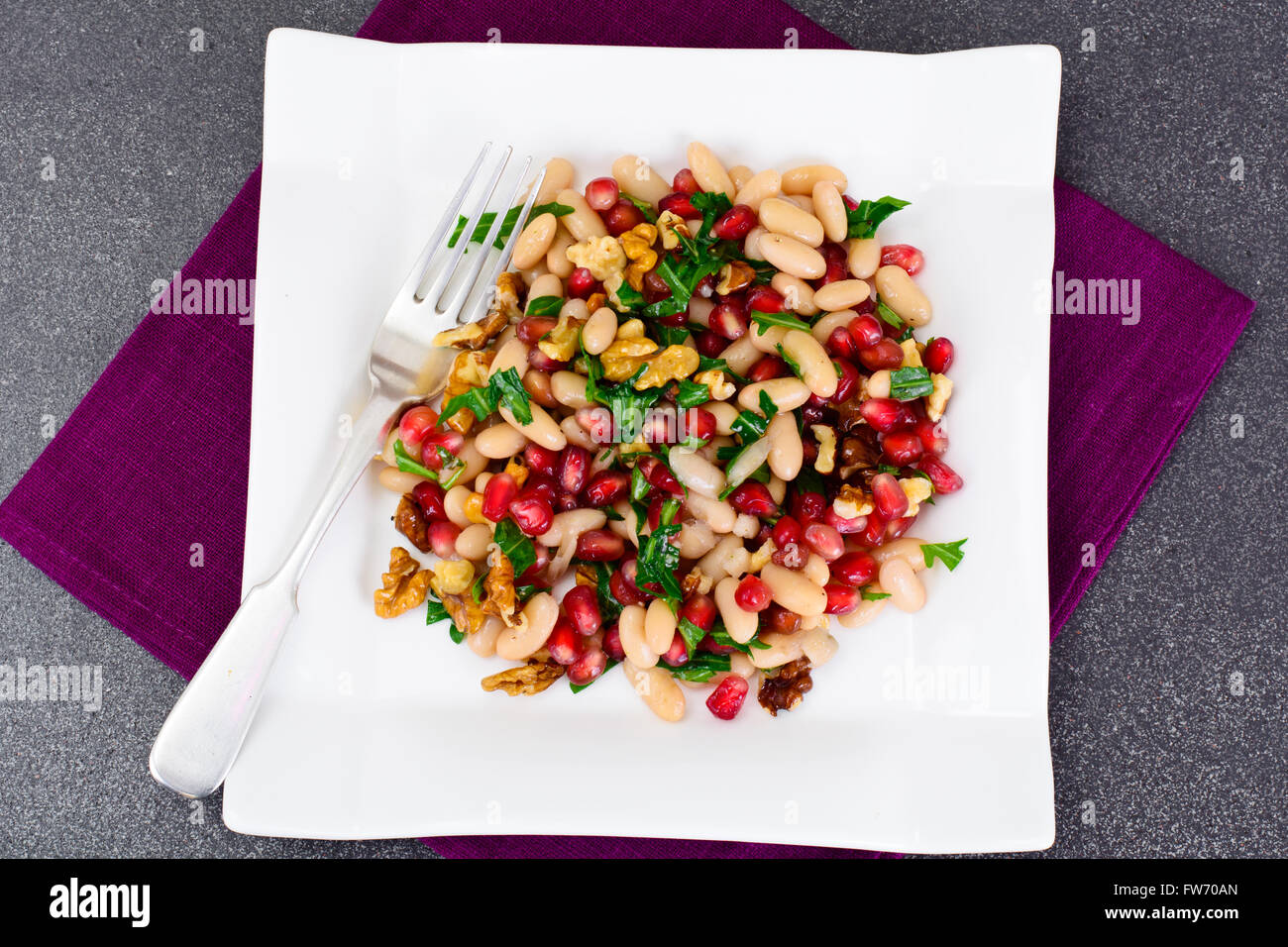 Weiße Bohnen mit Granatäpfeln, Walnüsse, Olivenöl, Zitronensaft Stockfoto