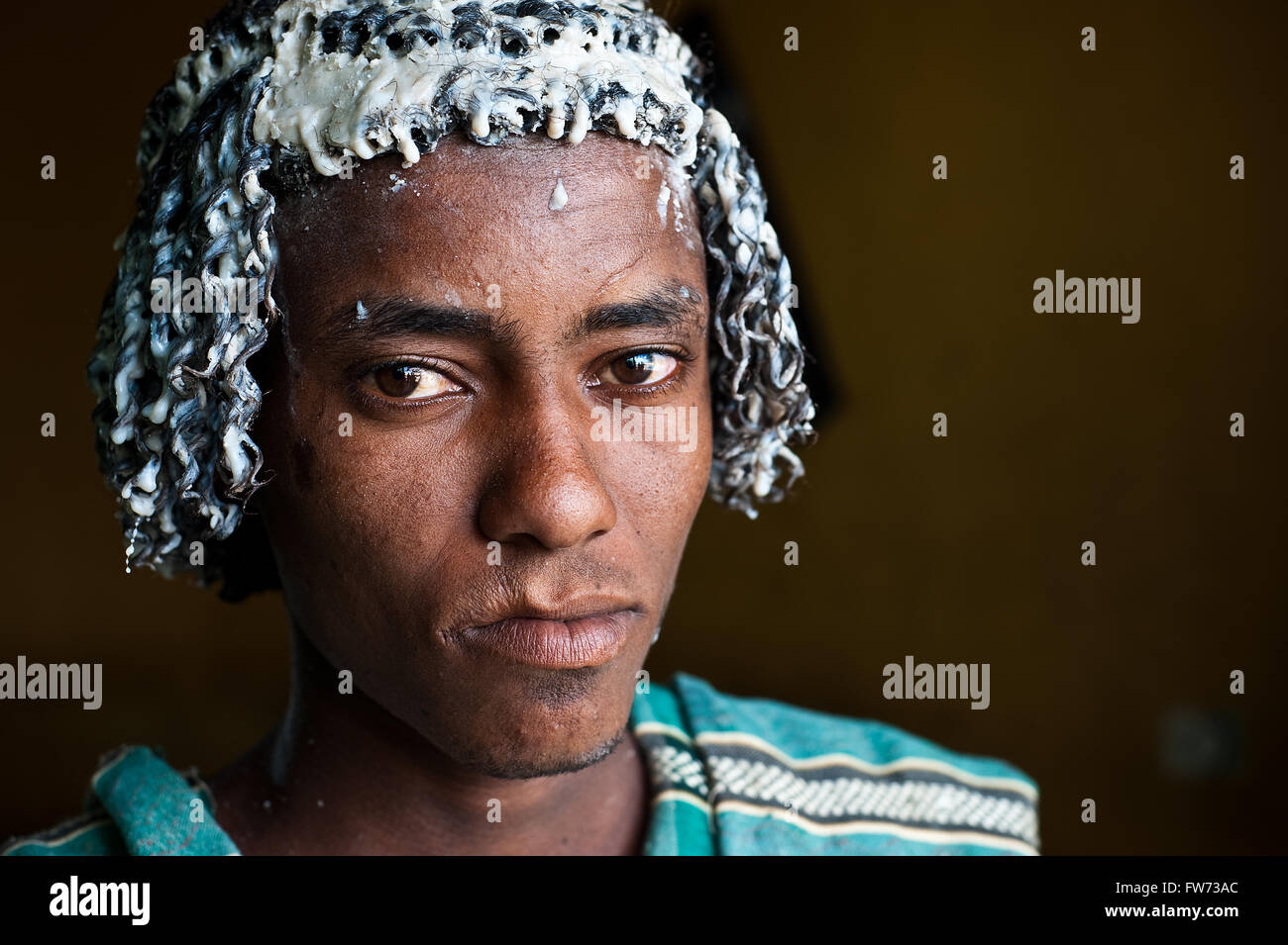 Junger Mann aus der Afar-Stamm. Der Afar-Tradition entsprechend hat er Butter auf seine Haare zu beschützen... Stockfoto