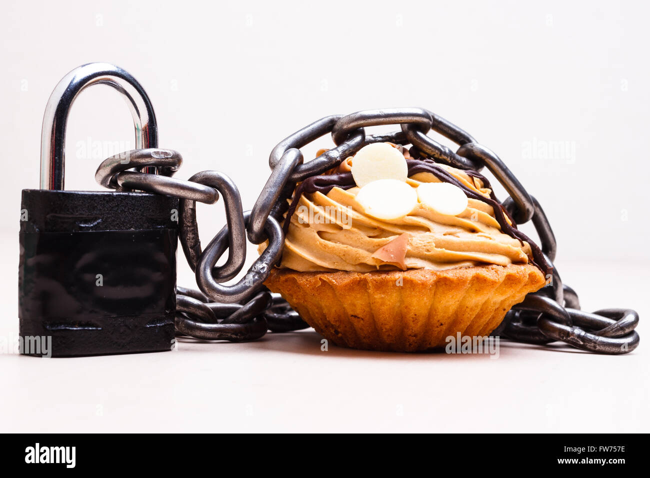 Diät-Zucker süßen Speisen sucht Konzept. Kuchen Kuchen verpackt in Metall-Kette und Vorhängeschloss Stockfoto