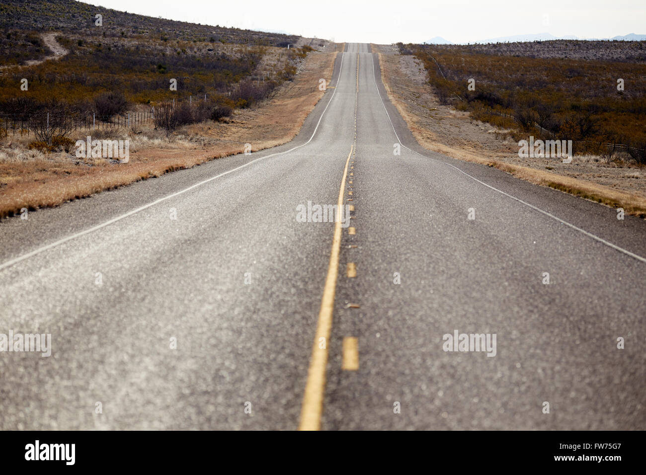 zweispurige Straße entlang der Texas-mexikanischen Grenze in der Nähe von Presidio, Texas, USA Stockfoto