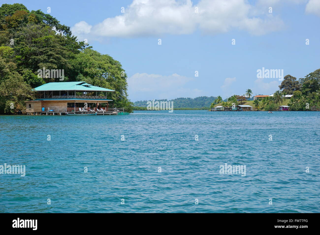 Loma Partida im Archipel von Bocas del Toro mit einem Restaurant über das Wasser auf der linken Seite, Panama Kanal Stockfoto