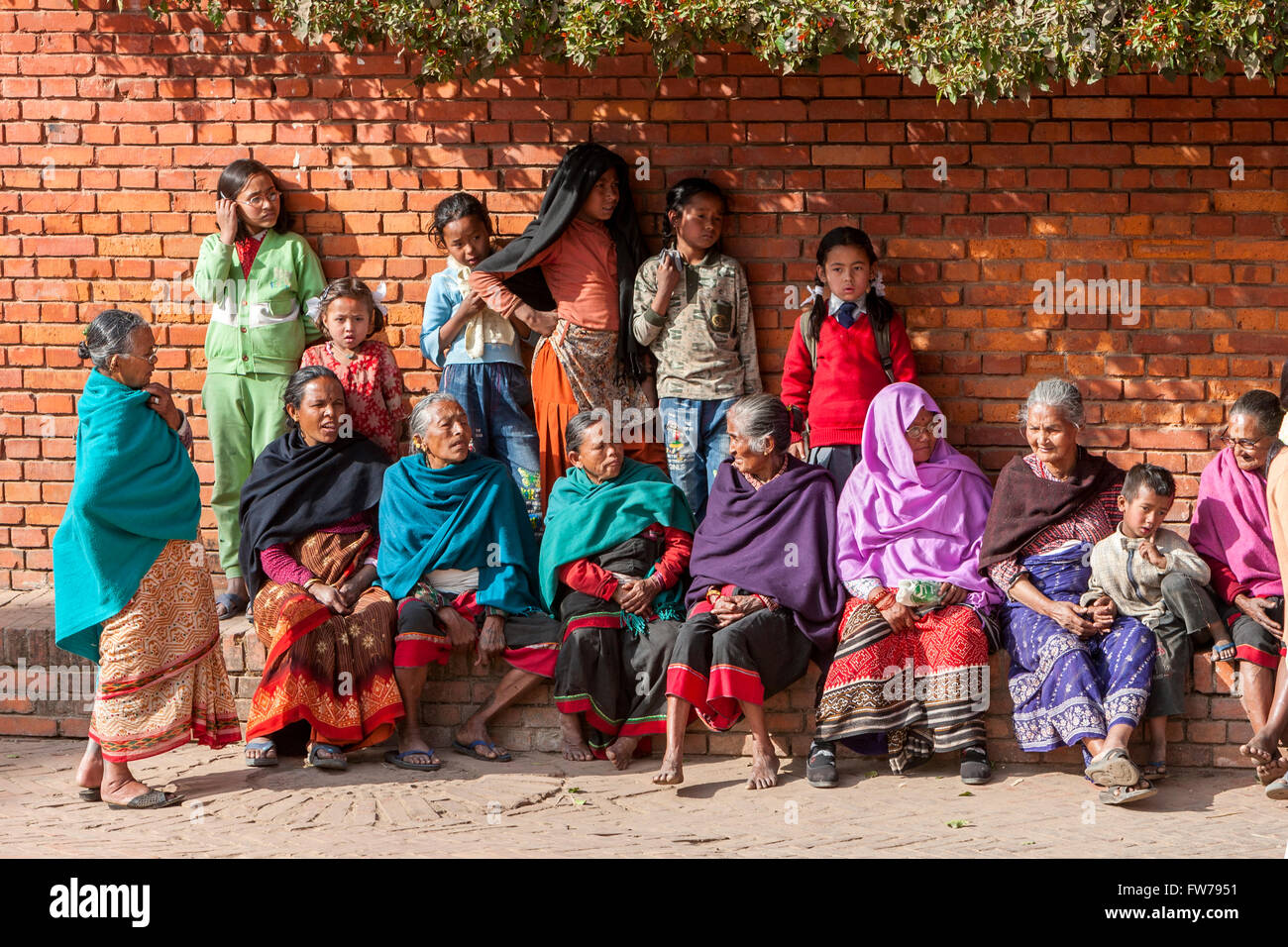 Bhaktapur, Nepal.  Frauen und Kinder am Durbar Square ausruhen. Stockfoto