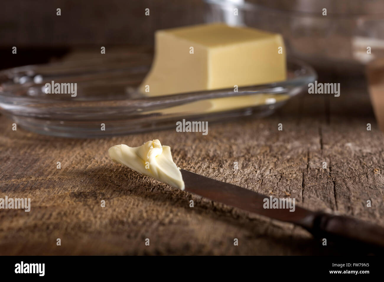 Messer mit Butter und Butterdose im Hintergrund Stockfoto