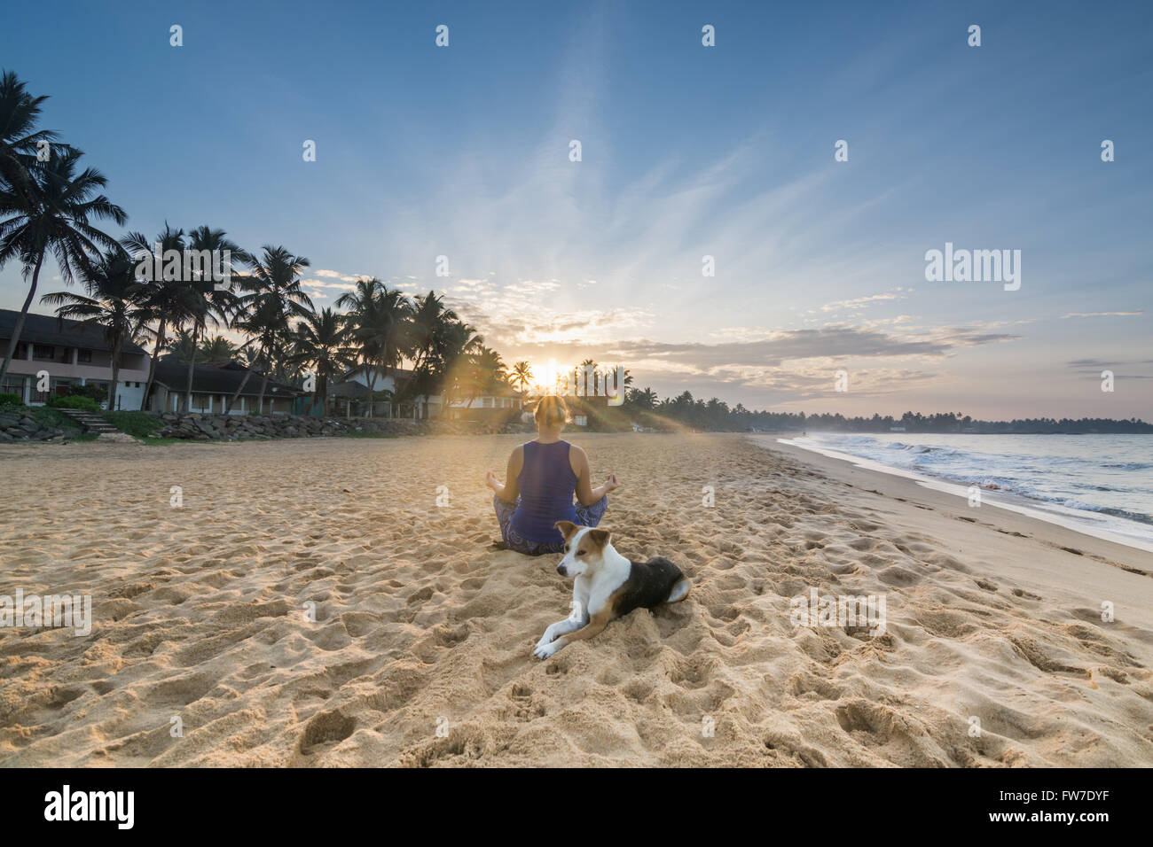 Junge Frau praktizieren Yoga am Strand von Hikkaduwa Stockfoto