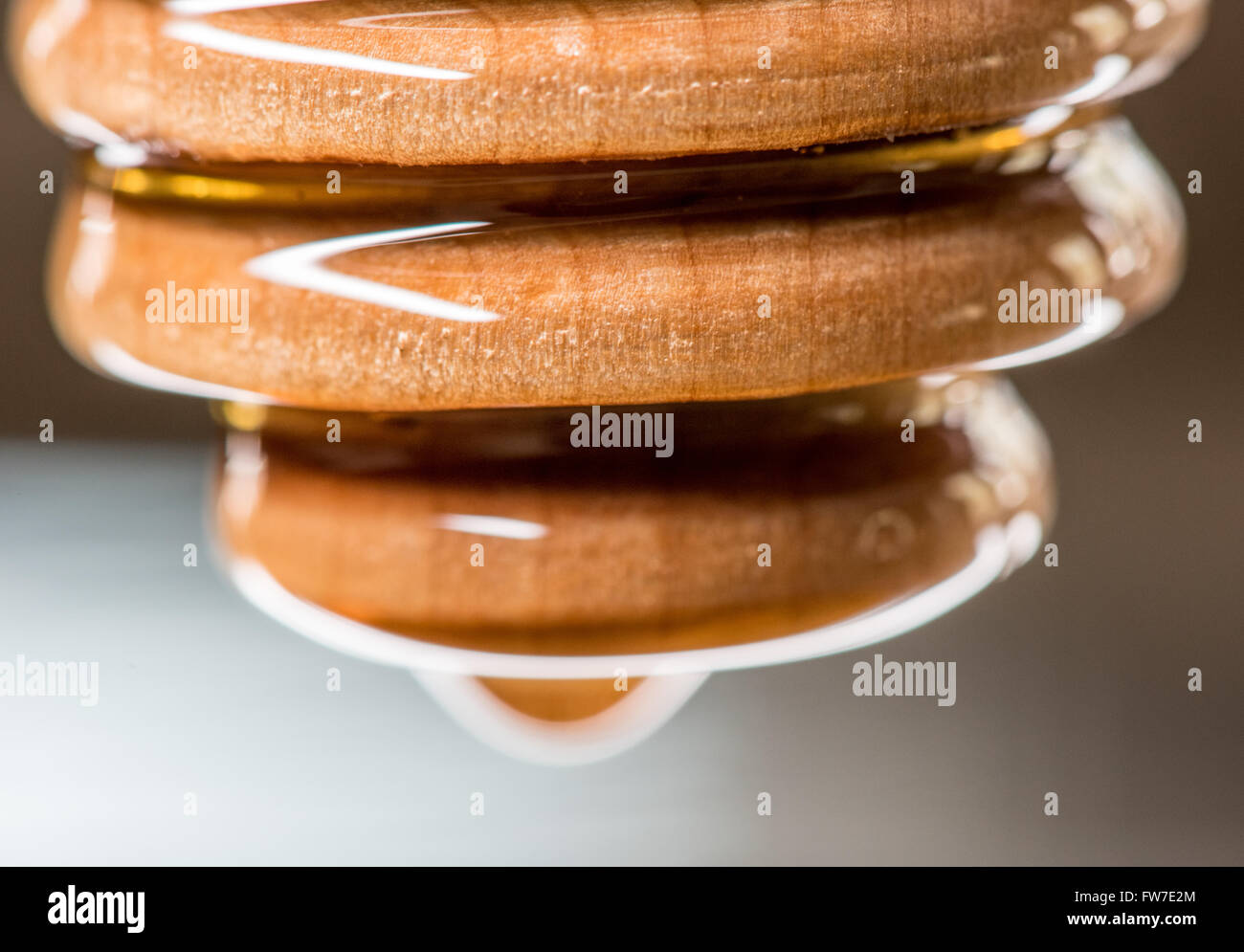 Close Up von beschichtet Honig Dipper reflektiert das Licht von der glatten Oberfläche des Honigs Stockfoto