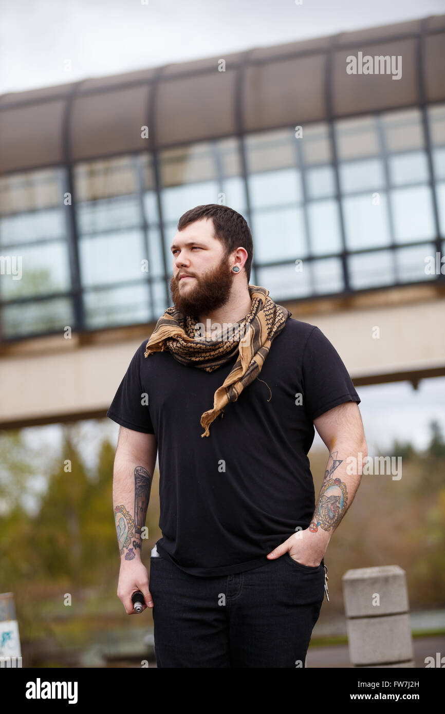 EUGENE, OR - 20. März 2016: Städtebauliches Portrait eines bärtigen Hipster-Menschen mit Tattoos. Stockfoto