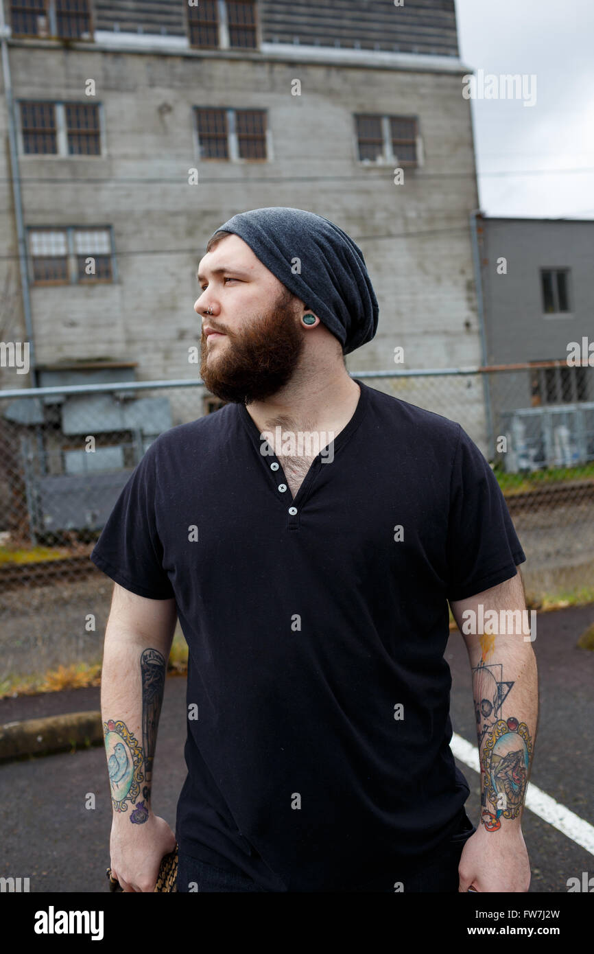 EUGENE, OR - 20. März 2016: Städtebauliches Portrait eines bärtigen Hipster-Menschen mit Tattoos. Stockfoto