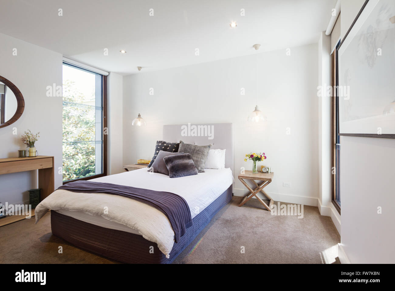 Luxus Innenraum gestaltete Schlafzimmer mit bequemen Kissen und Wurfwolldecke und Pendelleuchten Stockfoto