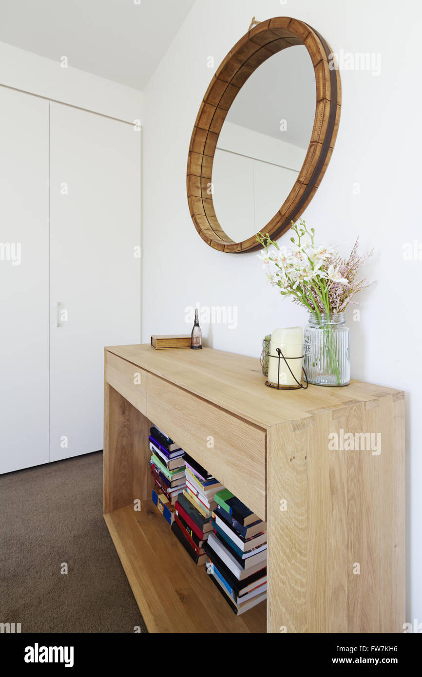 Innendekoration Styling der Anrichte aus Holz Buffet und Spiegel mit Kerze und Vase mit Blumen Stockfoto