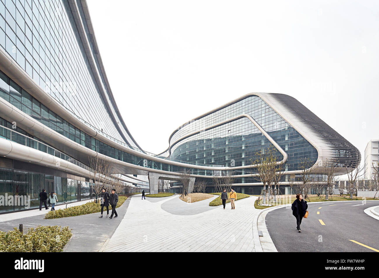 Gehweg und gebogenen Glas-Fassade mit Fußgängern und Straße. Himmel SOHO, Shanghai, China. Architekt: Zaha Hadid Architects Stockfoto