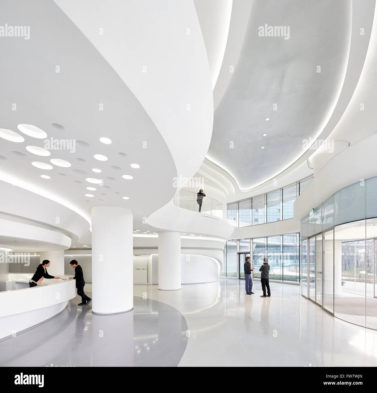 Gebogene und verglaste weiße Interieur des Empfangs. Himmel SOHO, Shanghai, China. Architekt: Zaha Hadid Architects, 2014. Stockfoto