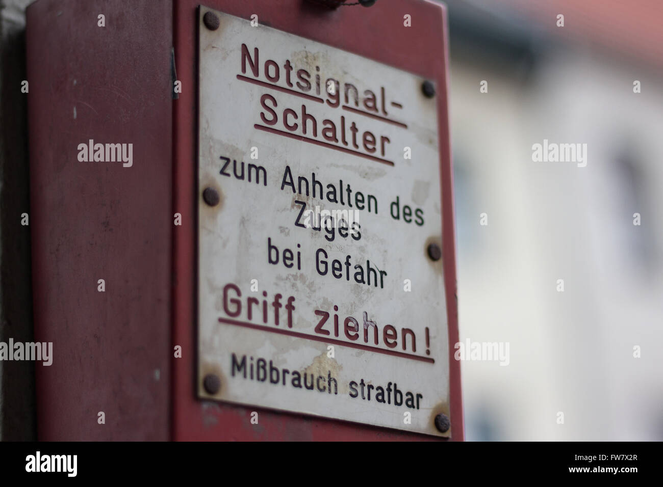 Nahaufnahme einer Notbremse an u-Bahnstation mit deutschem Text Spruch: Ziehgriff zu stoppen Stockfoto