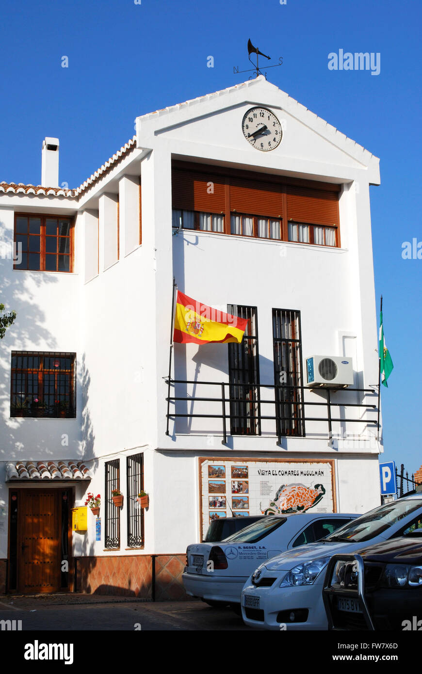 Rathaus mit Uhr und eine spanische Flagge auf dem Stadtplatz, Comares, Region Axarquia, Provinz Malaga, Andalusien, Spanien. Stockfoto