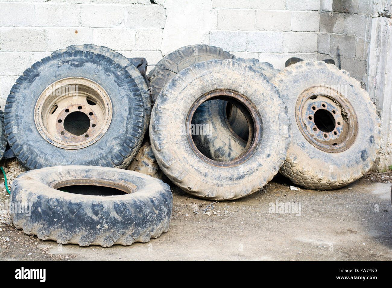 Traktorreifen verwendete Art der Mauer, mit Schlamm beschmiert Stockfoto