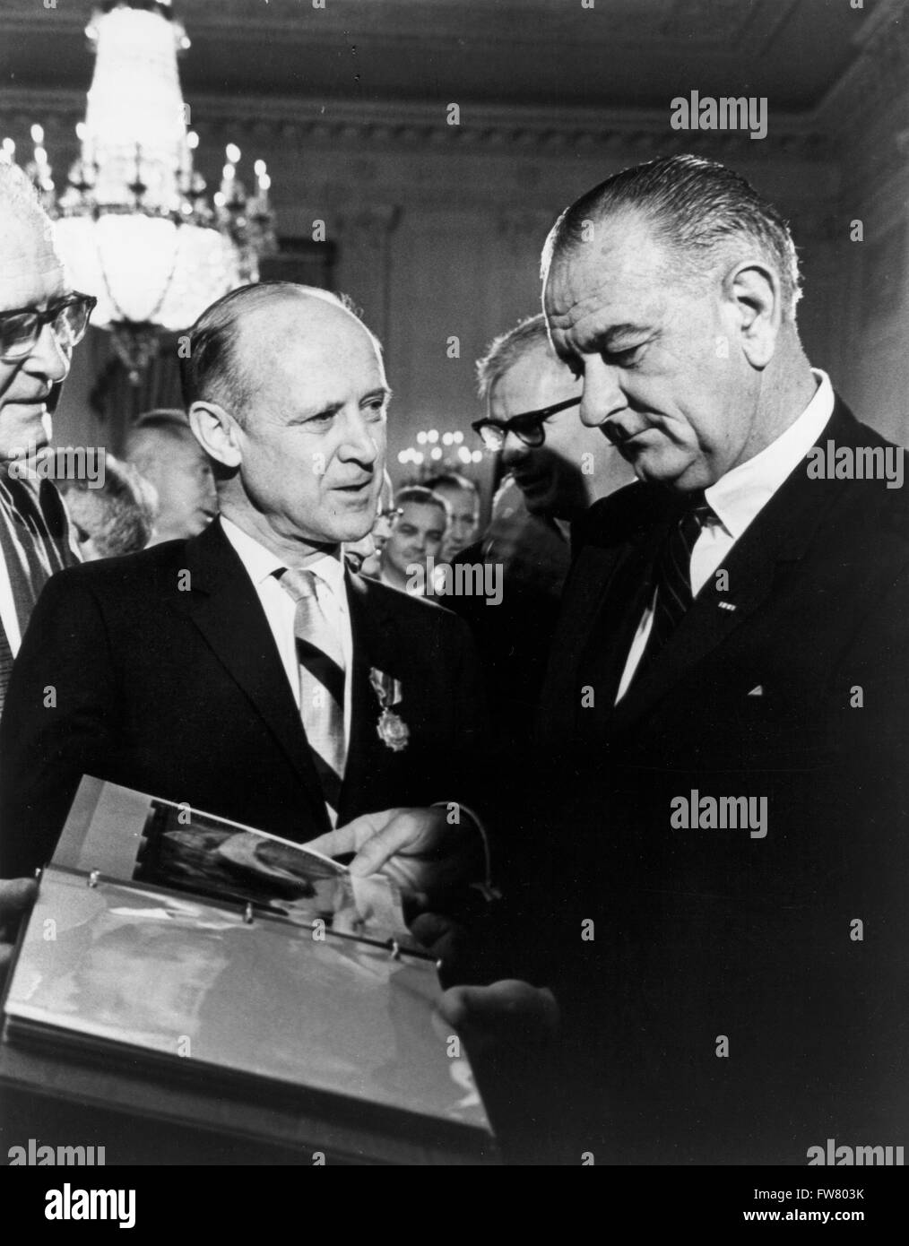 US-Präsident Lyndon B. Johnson wird mit einem Bindemittel von Fotografien von der Raumsonde Mariner von Direktor des Jet Propulsion Laboratory Dr. William H. Pickering im Weißen Haus 29. Juli 1965 in Washington DC vorgestellt. Stockfoto