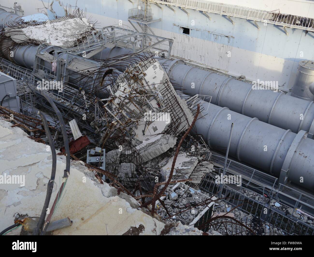 Trümmer vor den Überresten der Einheit 4 oberen Ebenen in das Kernkraftwerk Fukushima Daiichi 18. Dezember 2012 in Okuma, Japan. Die Pflanze erlitten eine katastrophale Kernschmelze im März 2011. Stockfoto