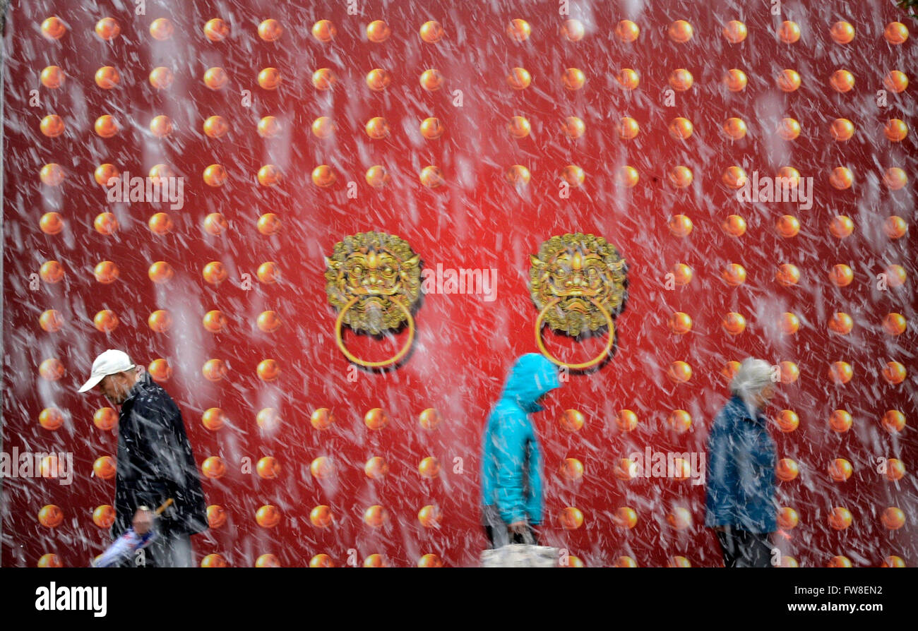 Yinchuan, Chinas autonomen Region Ningxia Hui. 2. April 2016. Fußgänger laufen im Schnee in Yinchuan, der Hauptstadt der nordwestlichen chinesischen autonomen Region Ningxia Hui, 2. April 2016. Schneefall traf die Stadt am Samstag, Unannehmlichkeiten für die Anwohner. © Wang Peng/Xinhua/Alamy Live-Nachrichten Stockfoto