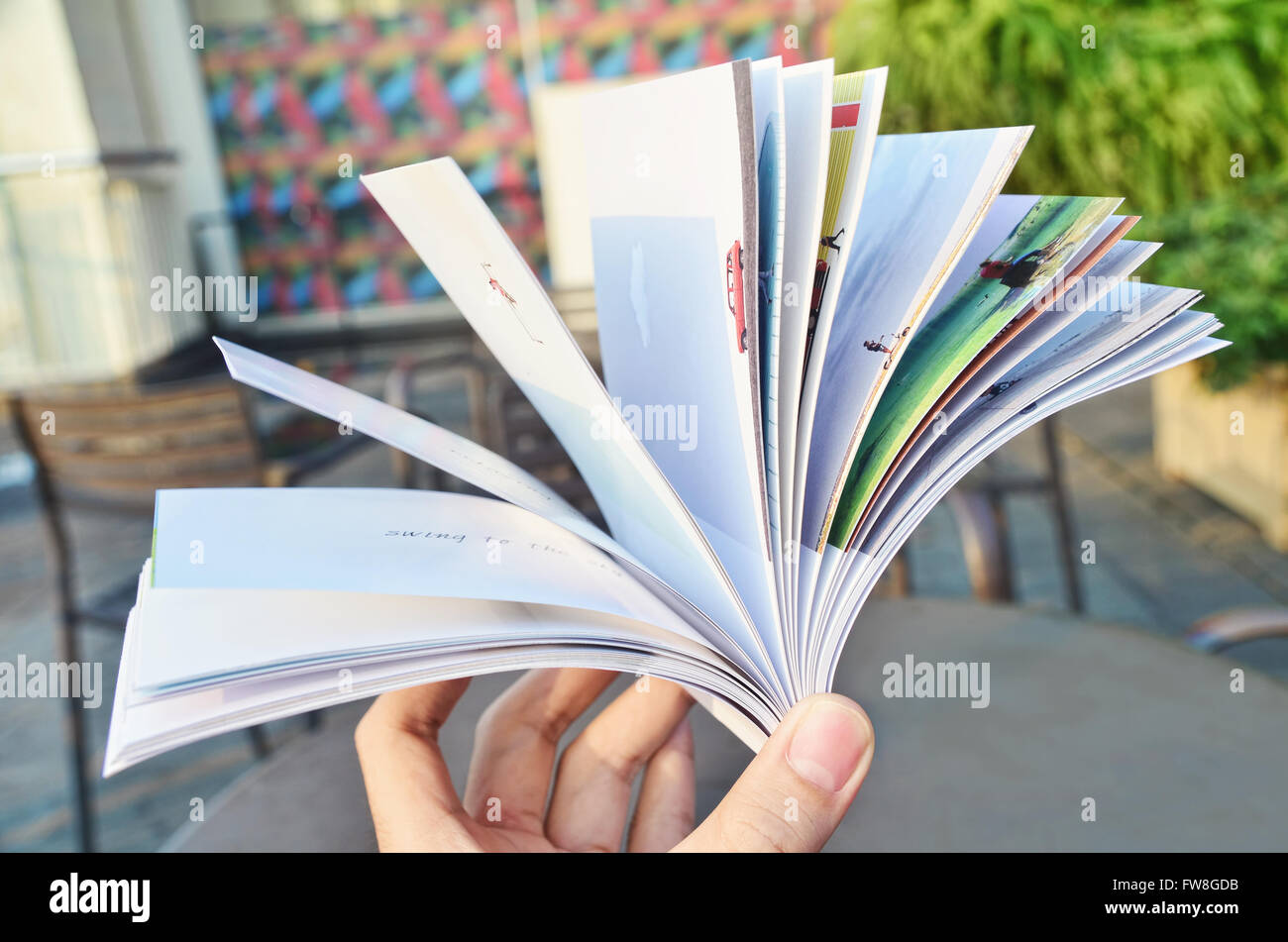Hand hält ein aufgeschlagenes Buch Stockfoto