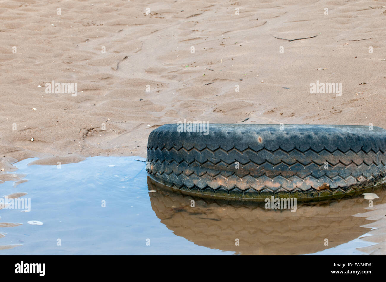 Alte Reifen an den verschmutzten Strand gespült Stockfoto
