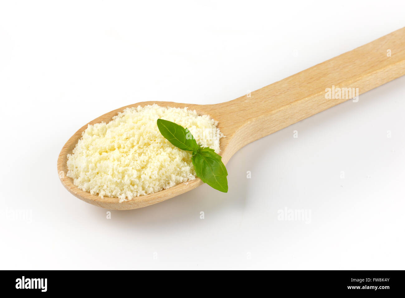 Löffel geriebener Parmesan mit Basilikum auf weißem Hintergrund Stockfoto