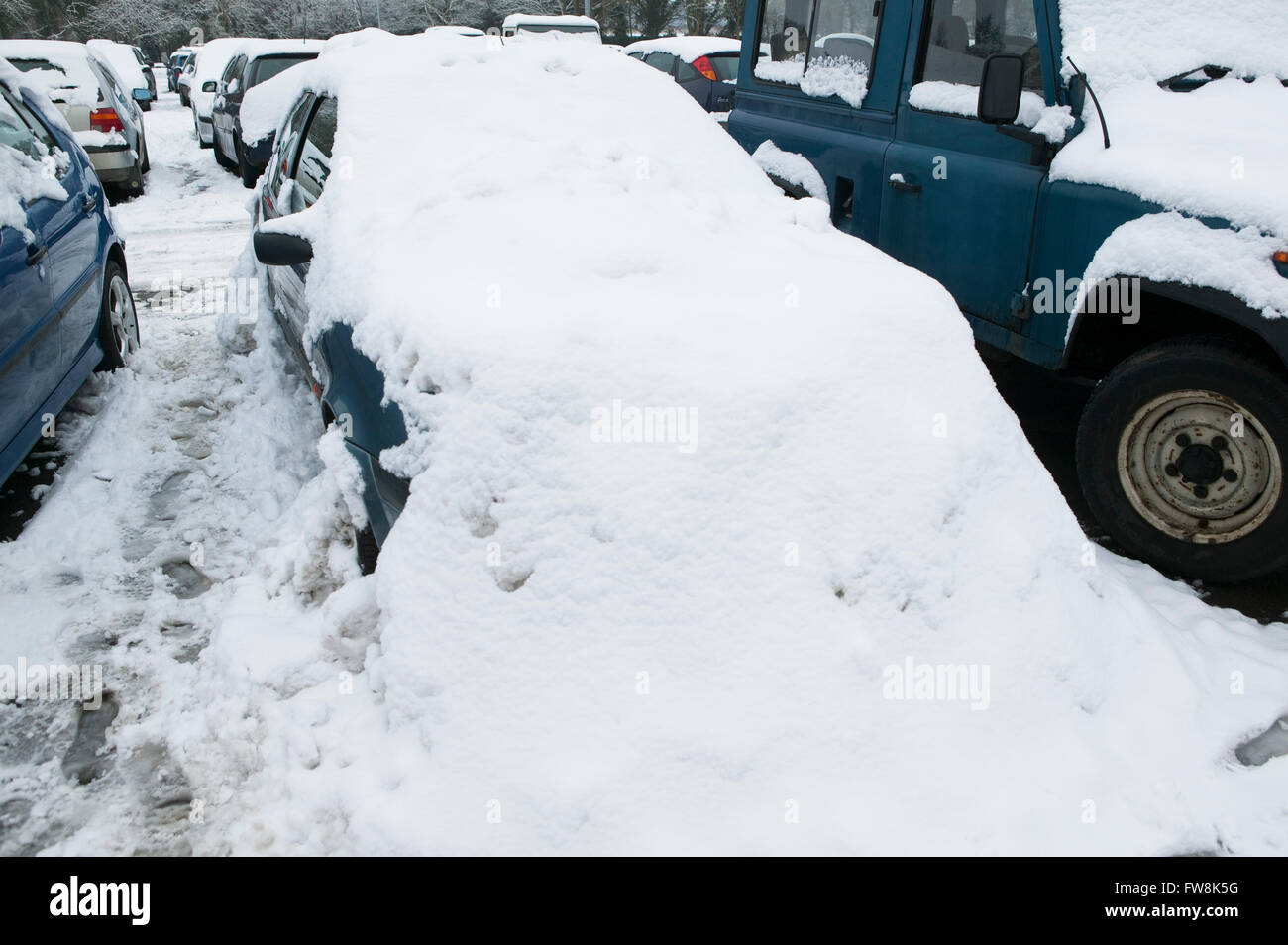 Auto unter dicken Schneedecke nach Sturm. Fahrzeuge unter Eis