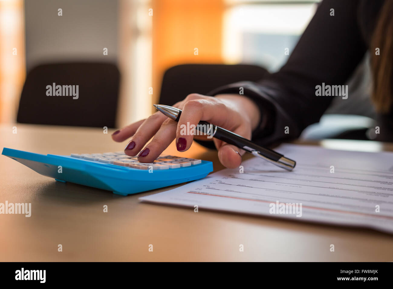 Geschäftsfrau, die Berechnung einer Rechnung in ihrem Büro Stockfoto