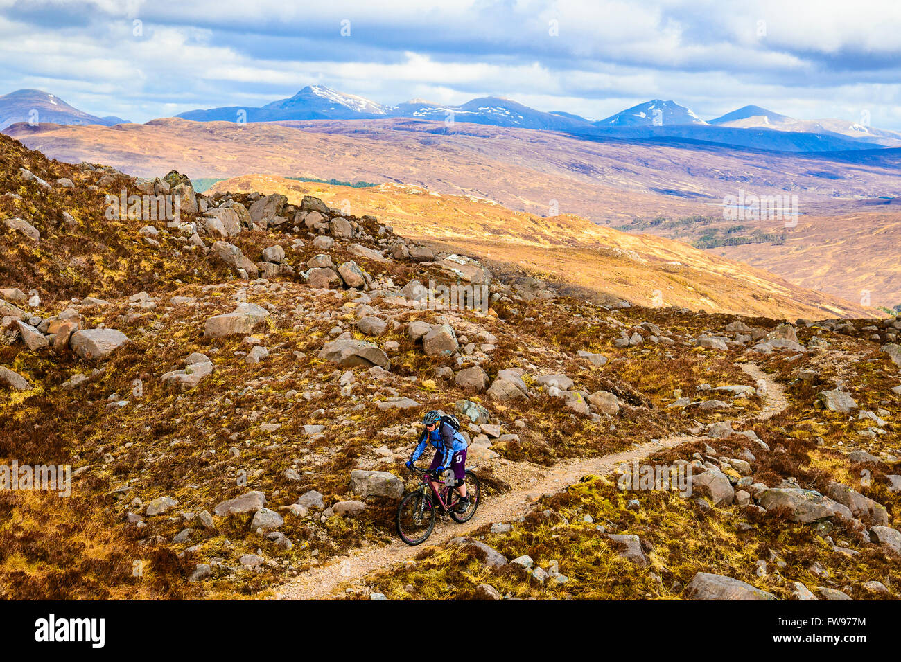 Mountainbiker auf Moorland über Glen Coulin in Torridon Highland Schottland mit den Gipfeln des Fannichs in der Ferne Stockfoto