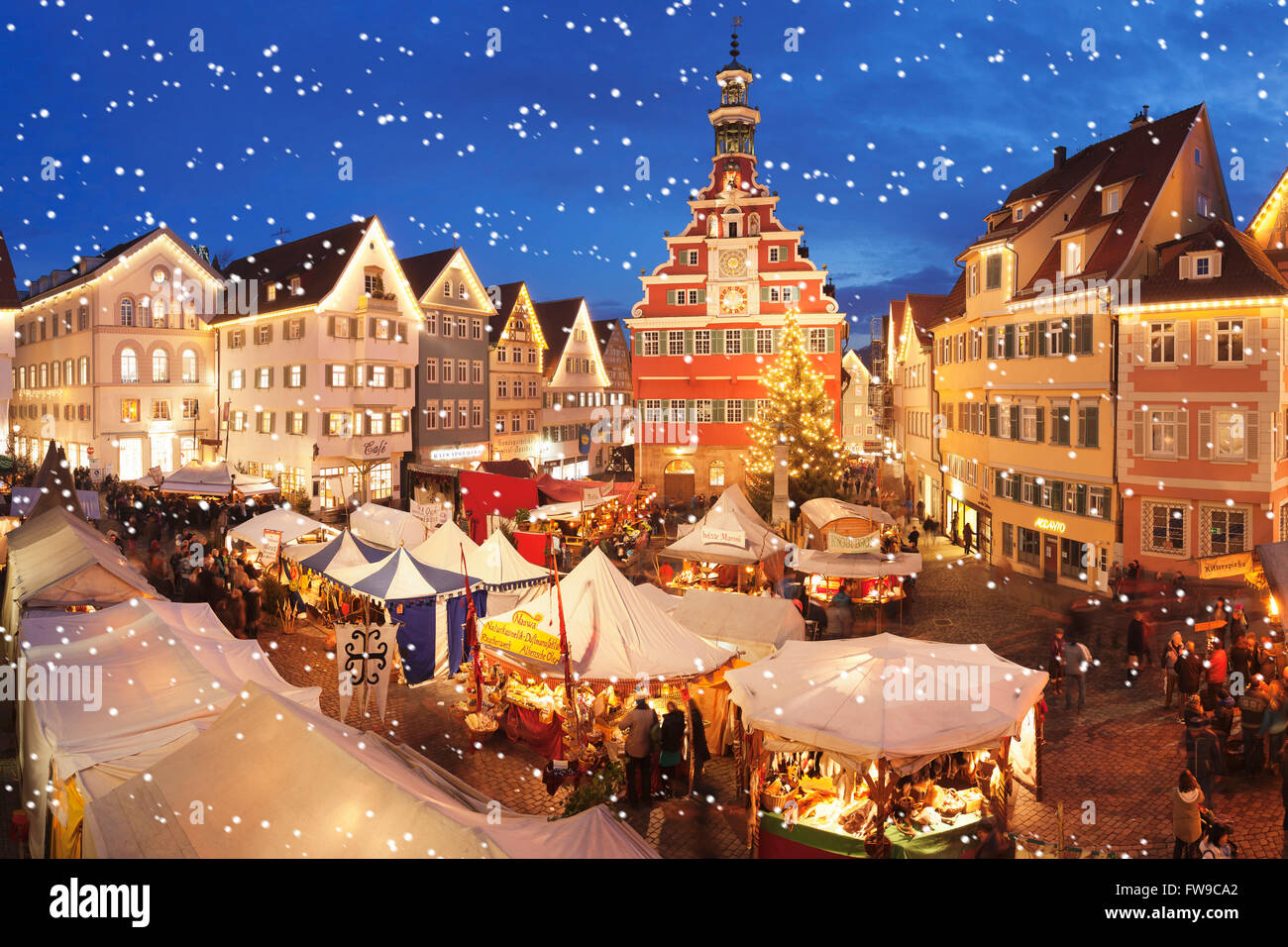 Beleuchteten Weihnachtsmarkt mit Schneeflocken gegen das alte Rathaus