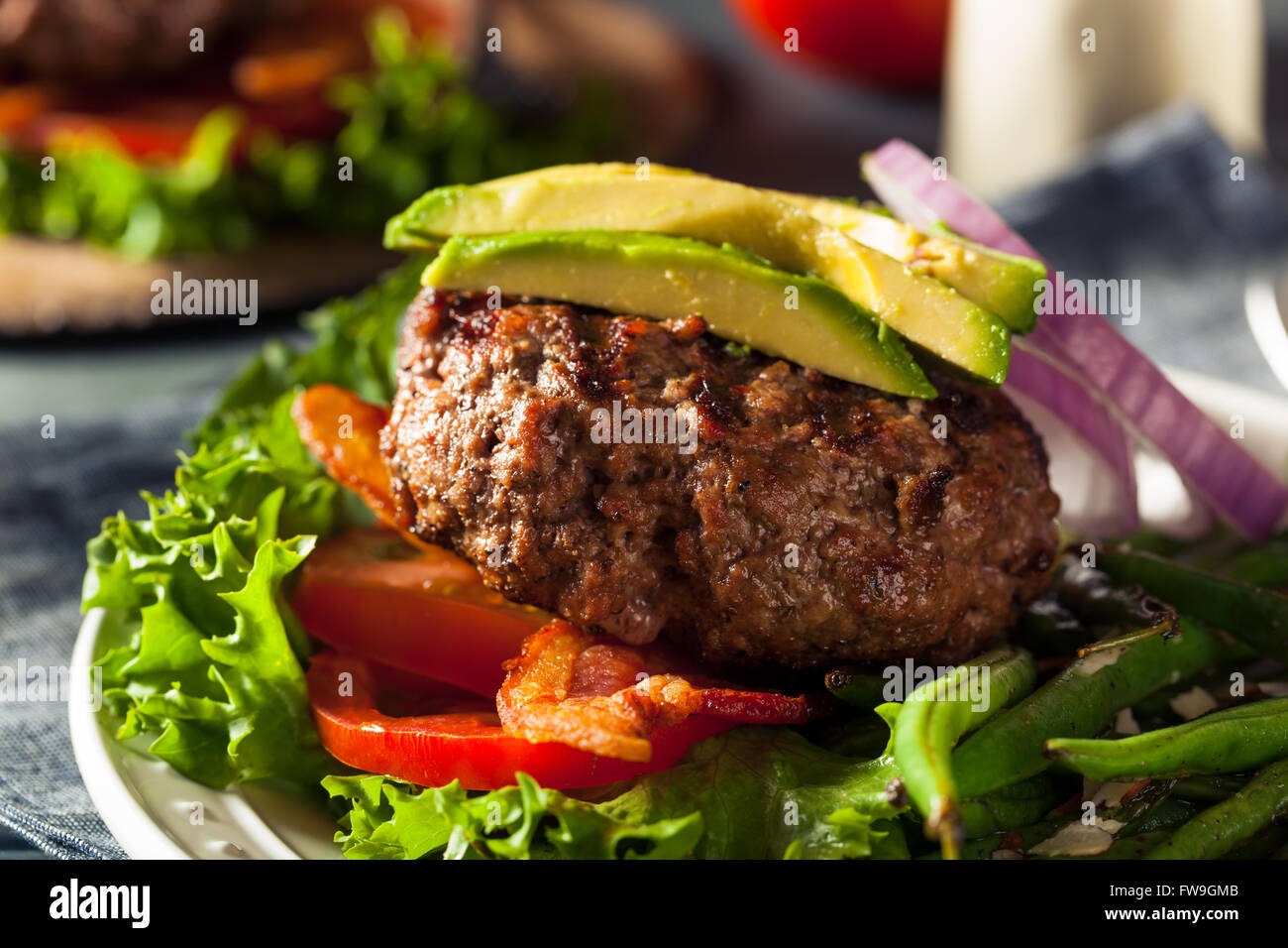 Frisch gegrillte Paleo Hamburger mit Gemüse und Speck Stockfoto