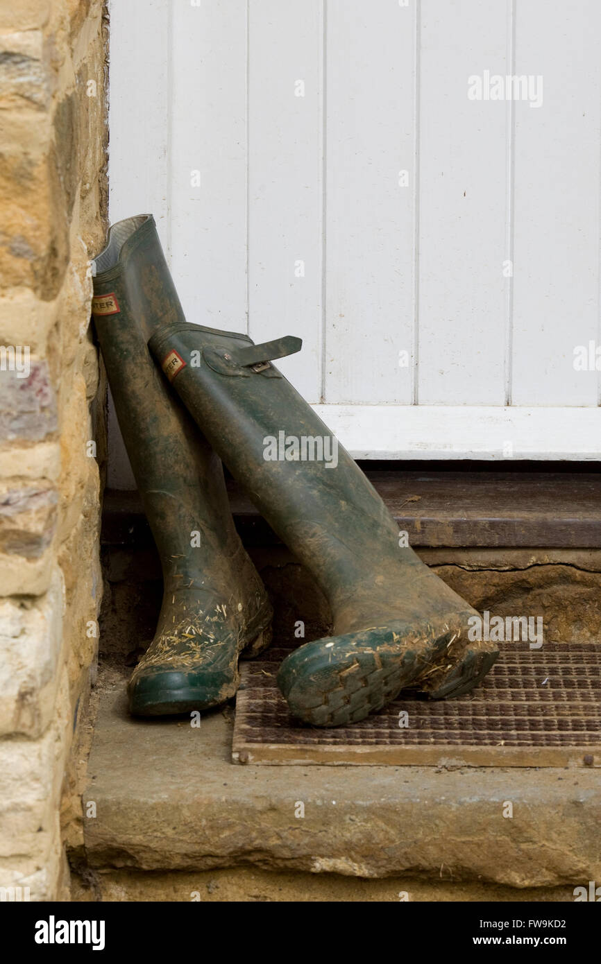 hölzerne Eingangstür mit Wellington boots in Tür in eine Landschaft Hütte Stockfoto