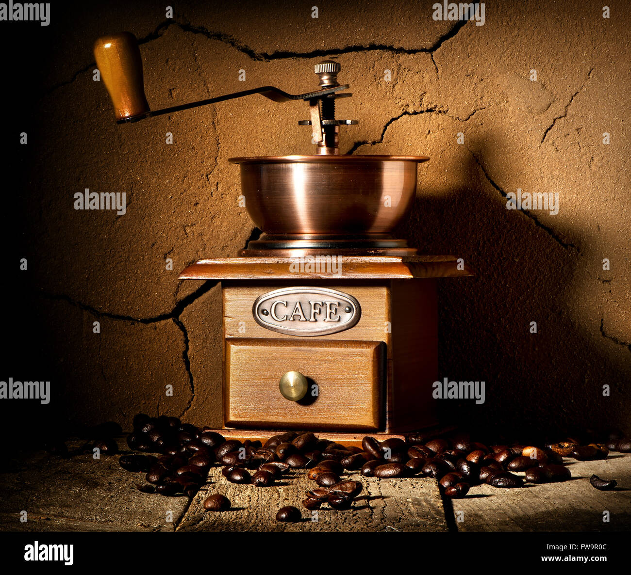 Holz Kaffee Mühle und Getreide Kaffee in der Nähe von Lehm Wand Stockfoto