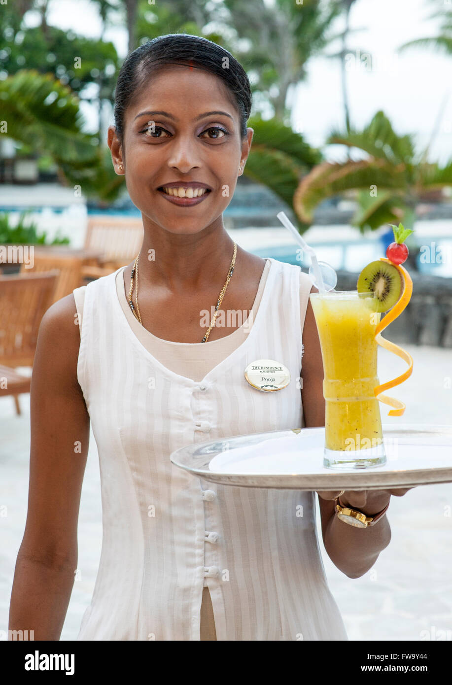 Kellnerin mit einem Cocktail im The Residence-Hotel in Mauritius. Stockfoto
