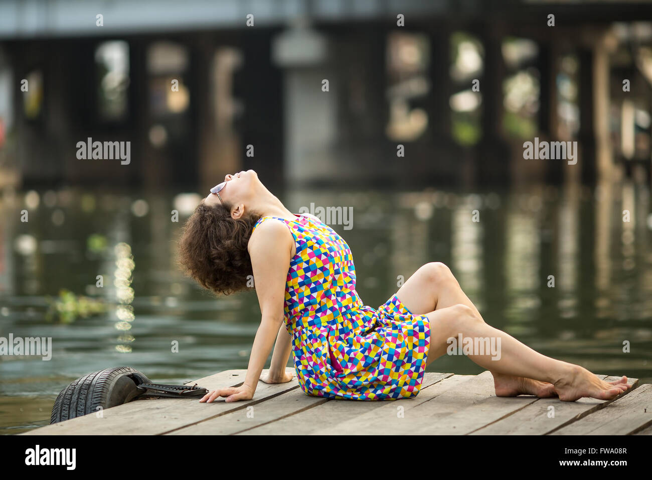 Schöne asiatische Frau mit Sonnenbrille in hölzernen Flußdamm. Stockfoto